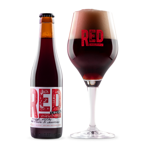 Fles RED by Petrus naast een glas op voet met diep donkerrood kersenbier